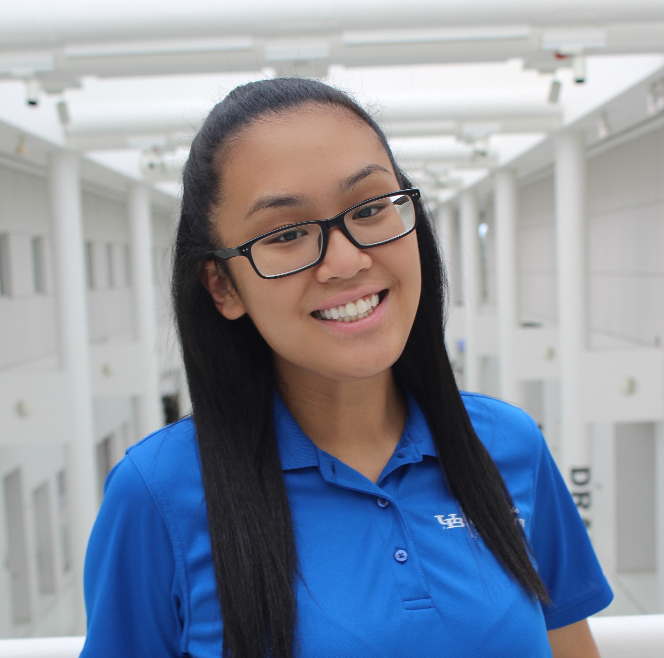 Judy wearing a blue polo smiling